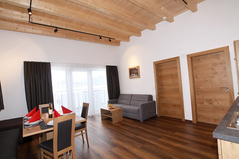 Esstisch mit Stühle und Sitzbank und Couch mit Tisch und Balkontür
